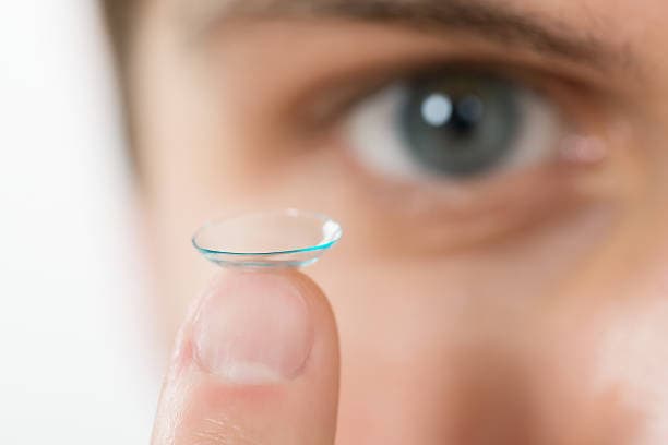 Soft contact lens on fingertip during cleaning and handling